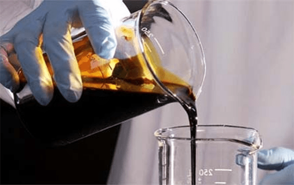 a man is pouring the contaminated hydraulic oil
